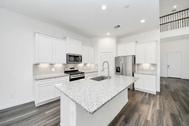 a kitchen with stainless steel appliances granite countertop a sink refrigerator and microwave