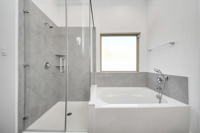 a white bath tub sitting next to a shower