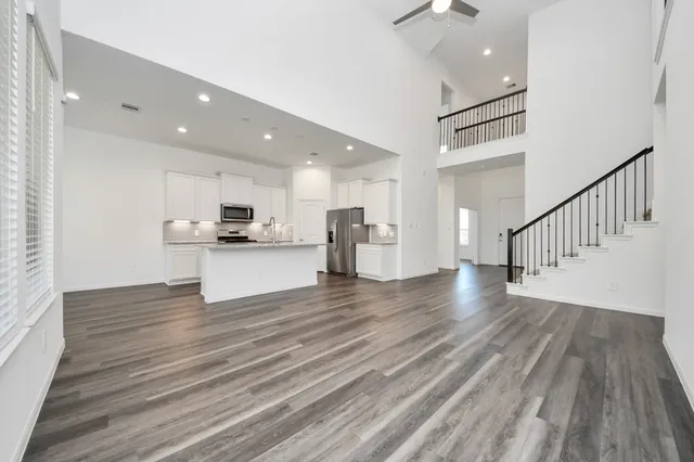 a view of kitchen view wooden floor stainless steel appliances and cabinets