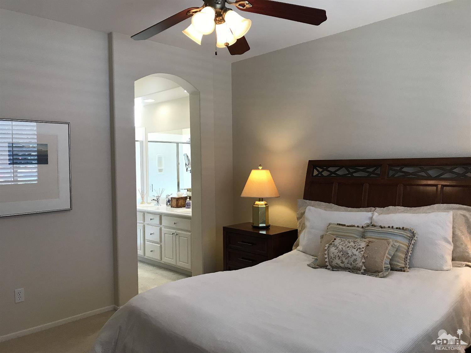 47848 Dancing Butterfly La Quinta, CA 92253 - Photo 16 of 36 a bedroom with a bed and a chandelier