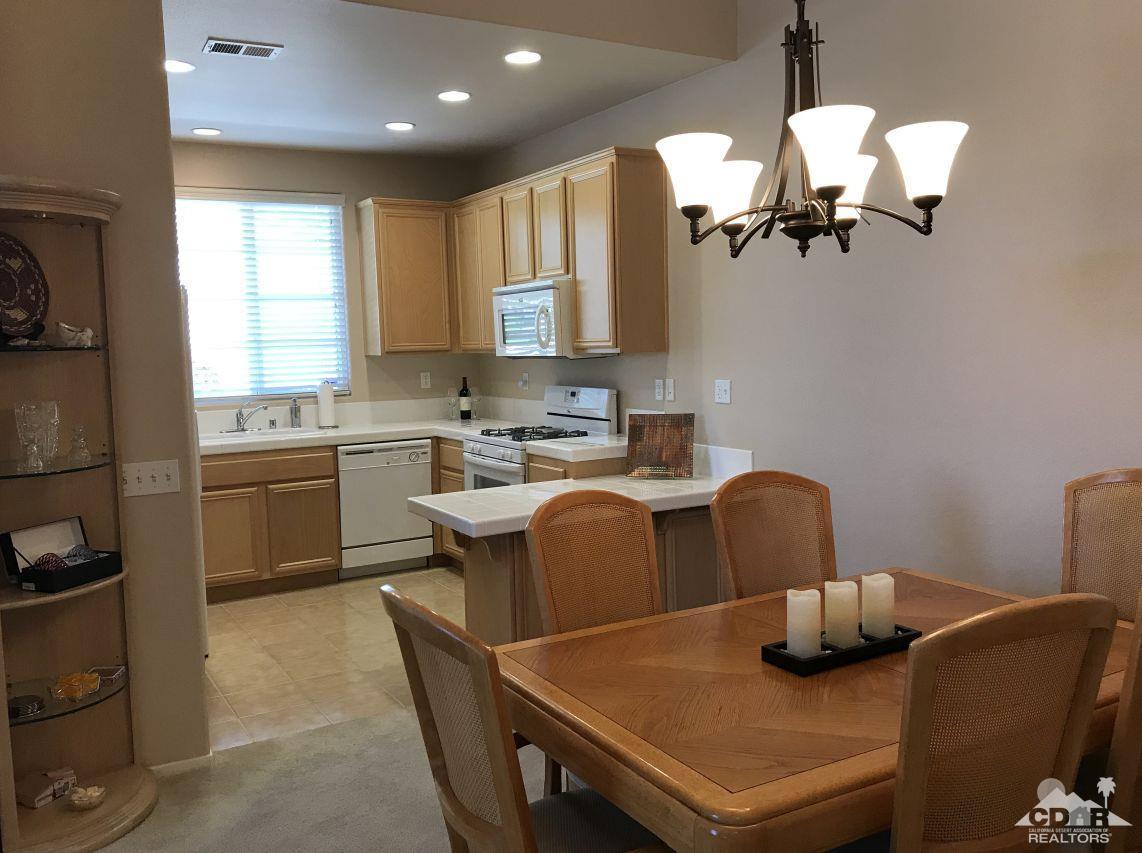47848 Dancing Butterfly La Quinta, CA 92253 - Photo 4 of 36 a kitchen with a table chairs a sink and dishwasher