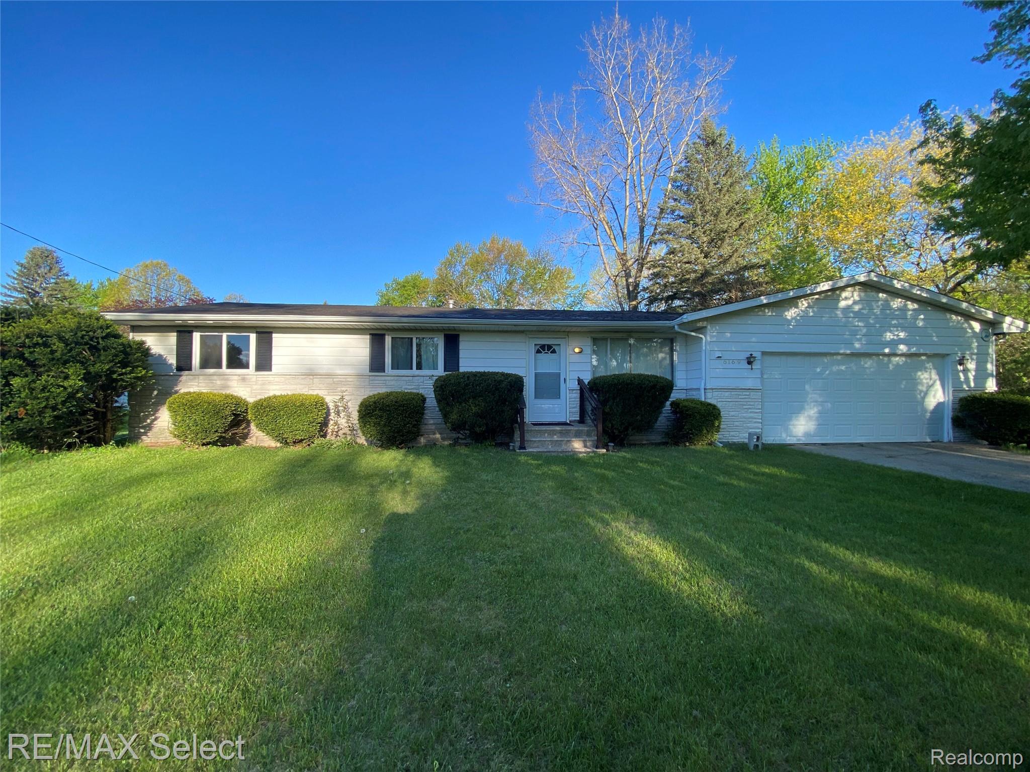 6169 Johnson Road Flushing, MI 48433 - Photo 27 of 28 Ranch-style home with a garage, a front yard, driveway, and brick siding