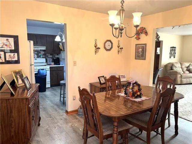 a view of a dining room with furniture and a chandelier