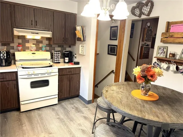 a kitchen with stainless steel appliances a dining table chairs and refrigerator view