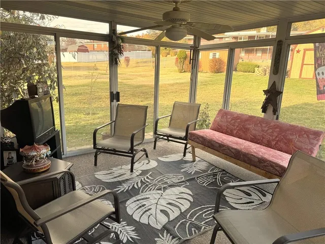a living room with furniture and a floor to ceiling window