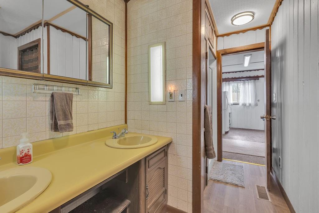 193 Salem Church Road Midland, PA 15059 - Photo 21 of 44 Owner's bathroom has double sinks, brand new floor, shower light, toilet- 01/2025. Shower to left was updated by current owner. Toilet to right.