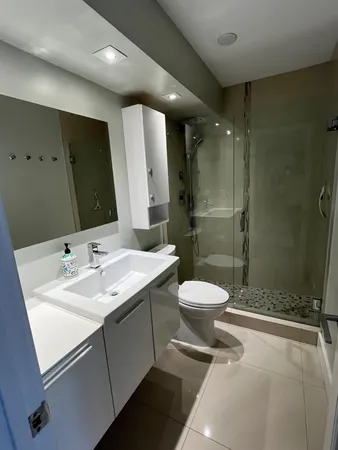 a bathroom with a toilet sink a mirror and shower