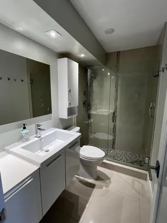 a bathroom with a double vanity sink toilet and shower