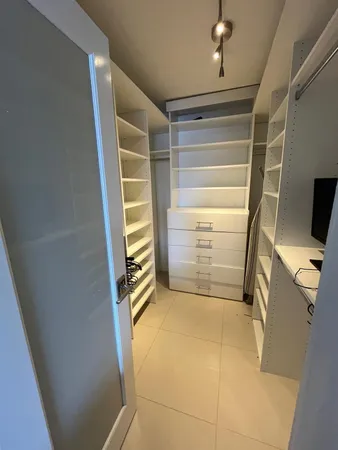 a view of walk in closet with clothes