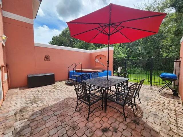 a view of a patio with table and chairs under an umbrella