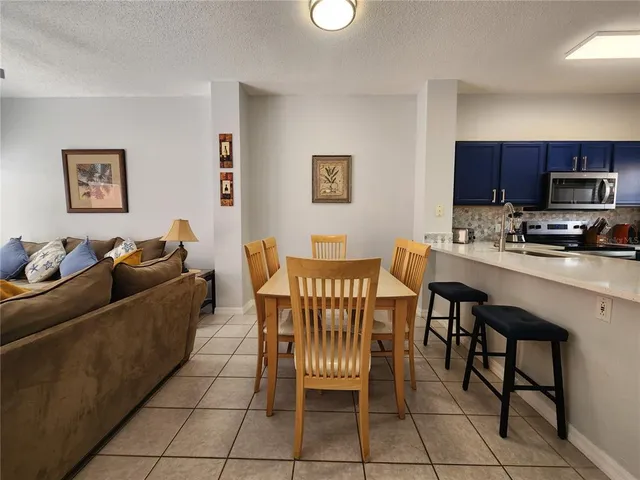 a living room with furniture a flat screen tv and kitchen view