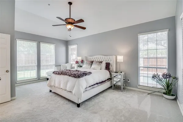 a bed sitting in a spacious bedroom next to a window