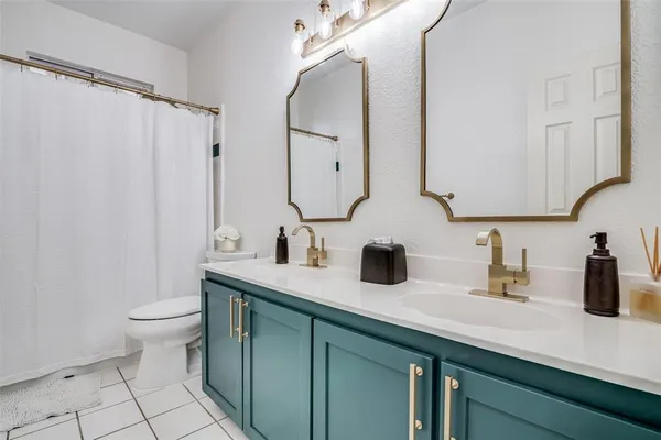 a bathroom with a double vanity sink mirror and toilet