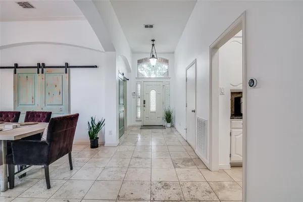 a view of a hallway with furniture and a chandelier