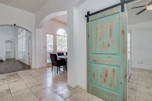 a view of a hallway with windows and chandelier