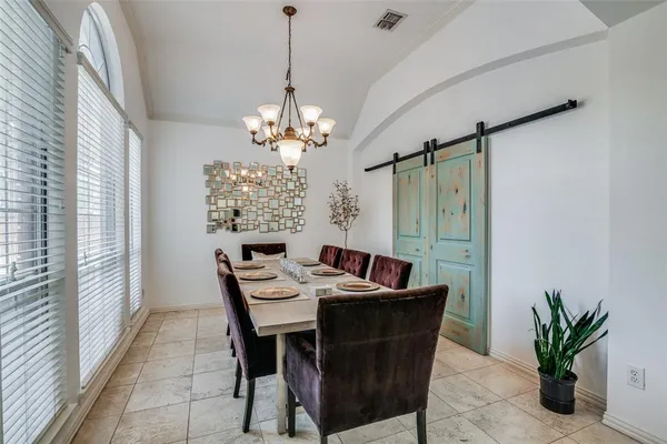 a dining room with furniture a chandelier and window