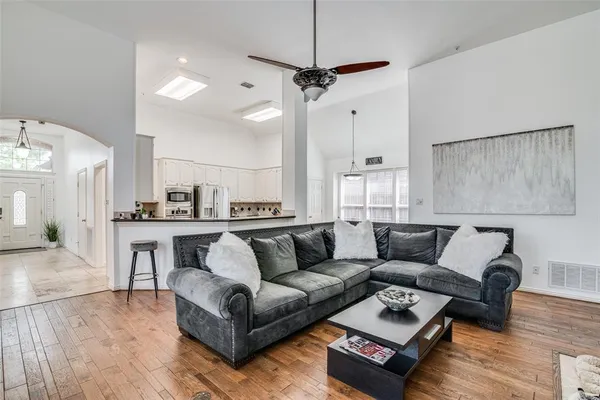 a living room with furniture and a wooden floor
