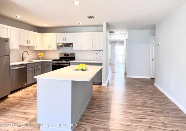 a kitchen with stainless steel appliances a refrigerator sink and cabinets