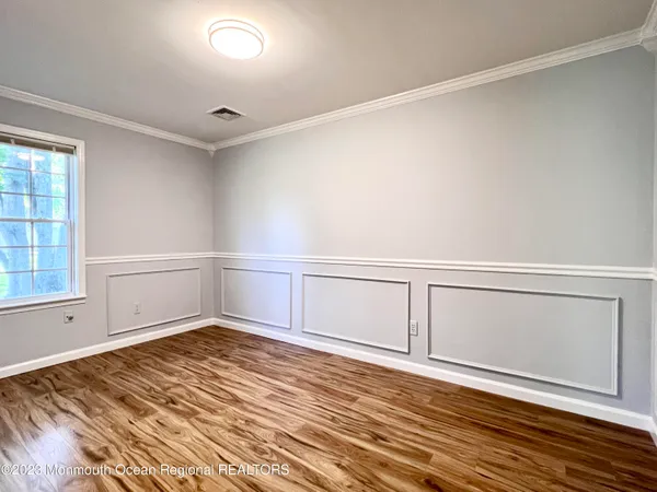 an empty room with wooden floor and white walls