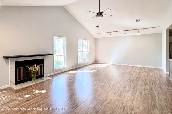 a view of an empty room with a fireplace and a window
