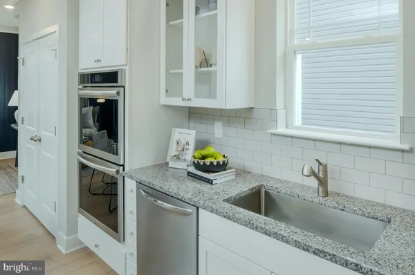 a kitchen with stainless steel appliances granite countertop a sink and a microwave