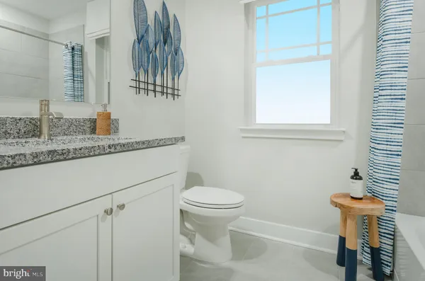 a bathroom with a granite countertop sink a toilet and a mirror