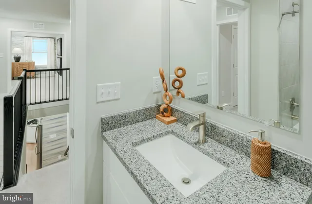 a bathroom with a granite countertop sink and a mirror