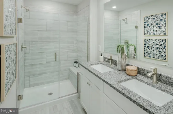 a bathroom with a granite countertop sink a mirror and shower