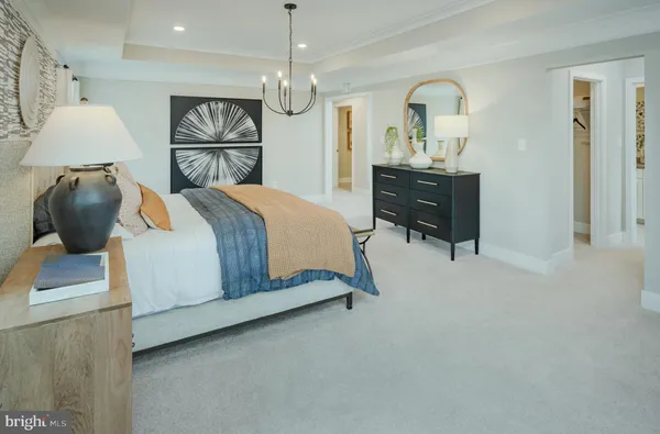 a bedroom with a bed a chandelier and a dresser