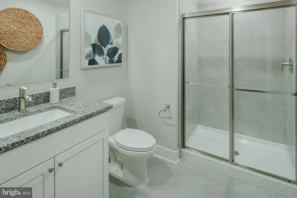 a bathroom with a granite countertop sink a toilet and a mirror