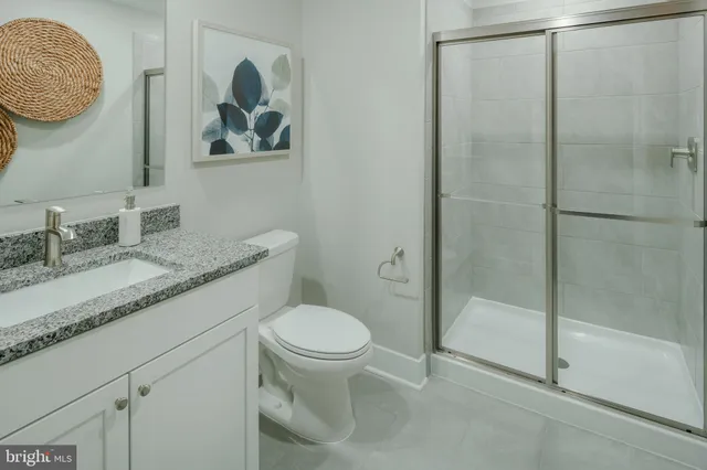 a bathroom with a granite countertop sink a toilet and a mirror