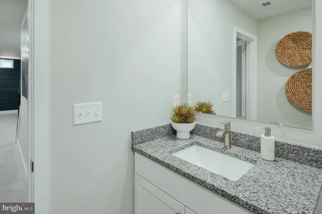 a bathroom with a granite countertop sink and a mirror