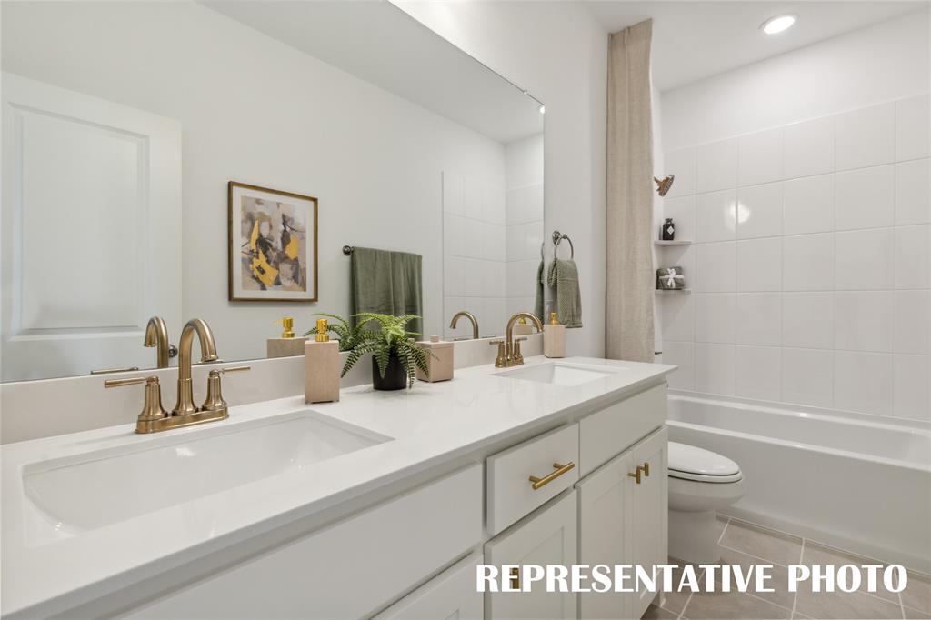 1303 Rooted Road Frisco, TX 75033 - Photo 11 of 14 a bathroom with a granite countertop sink a toilet a large mirror and shower