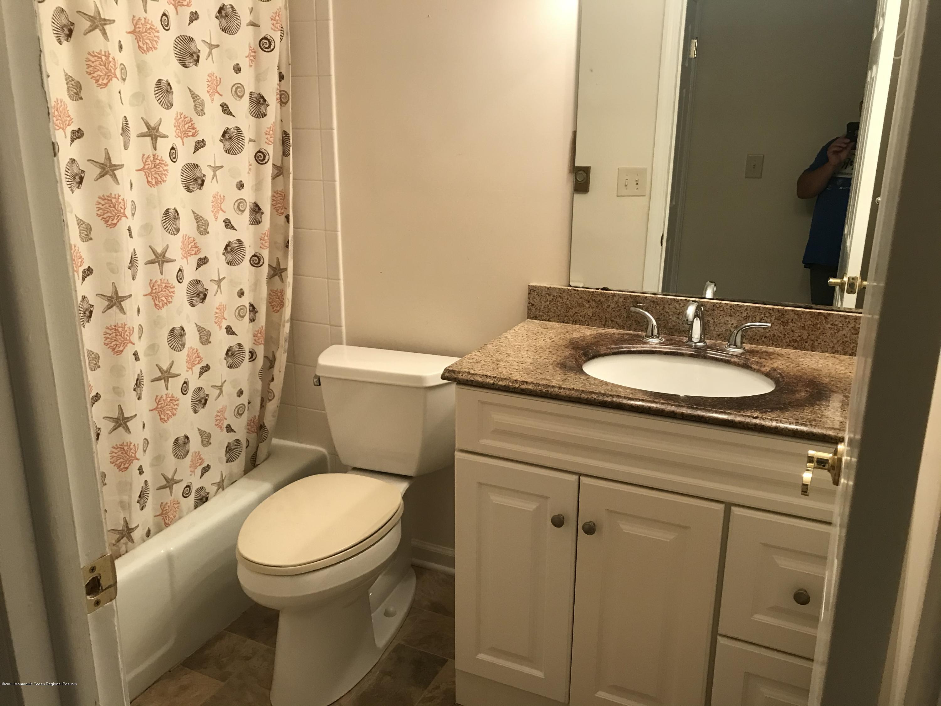 2 Cranberry Road, Unit 10A Manahawkin, NJ 08050 - Photo 17 of 20 a bathroom with a granite countertop toilet sink and mirror