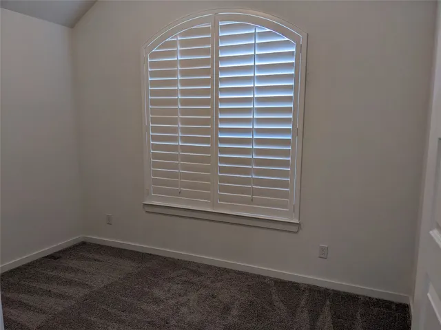 a view of a room that has a window and a ceiling fan