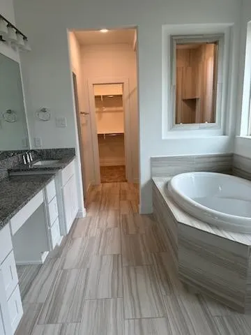 a kitchen with stainless steel appliances granite countertop a sink dishwasher a stove wooden floor and a granite counter top