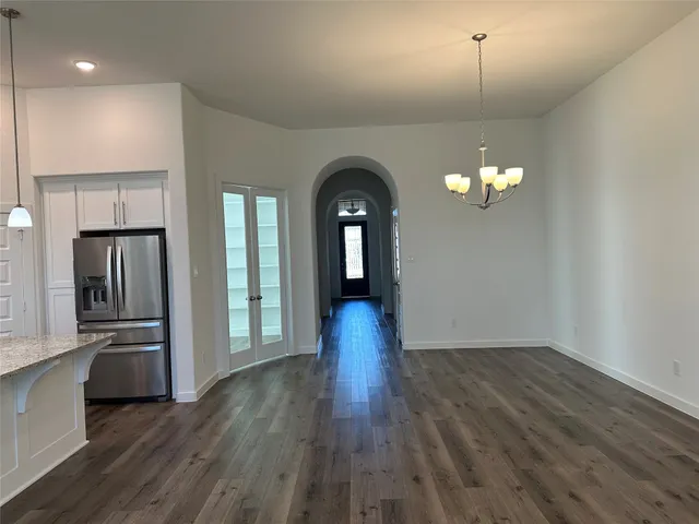 a view of a room with wooden floor staircase and a kitchen