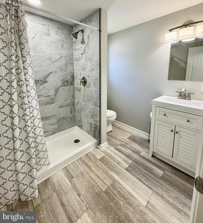 a bathroom with a sink a toilet and shower