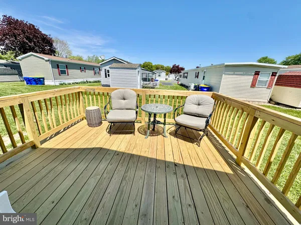 a view of a balcony with two chairs and wooden floor