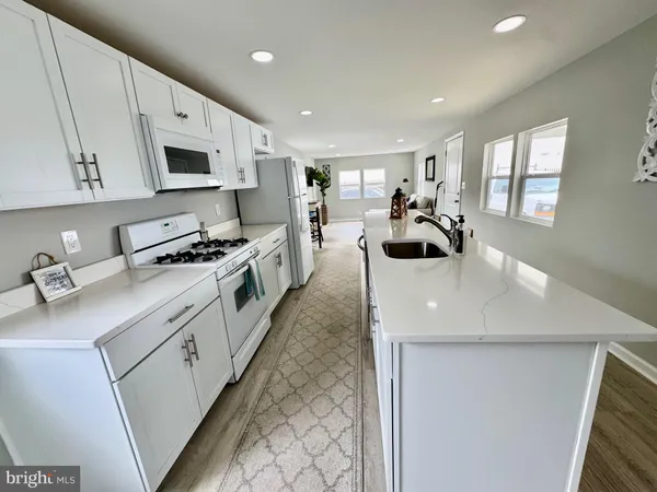 a kitchen with stainless steel appliances a stove a sink a microwave and cabinets