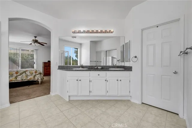 a spacious bathroom with a granite countertop sink a mirror and a bathtub