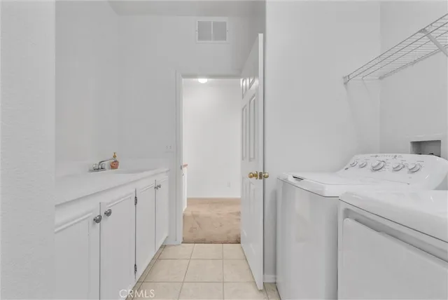 a utility room with cabinets washer and dryer