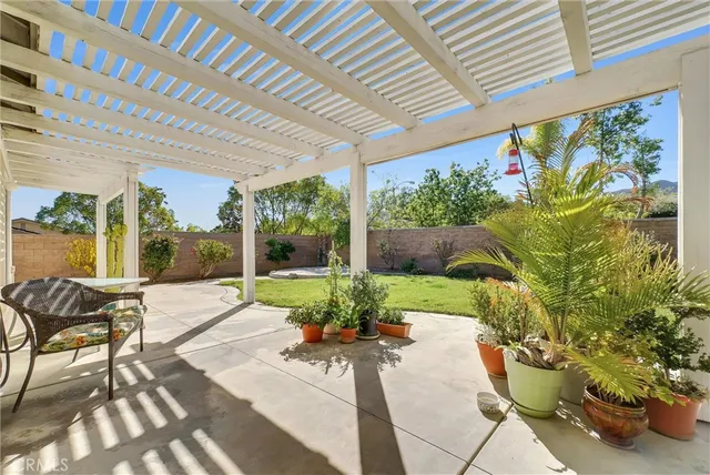 a view of a patio with chair and table potted plants