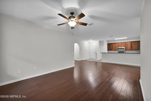 a view of a room with wooden floor and a ceiling fan