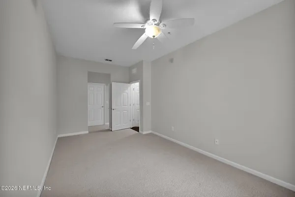 an empty room with a ceiling fan and a fan