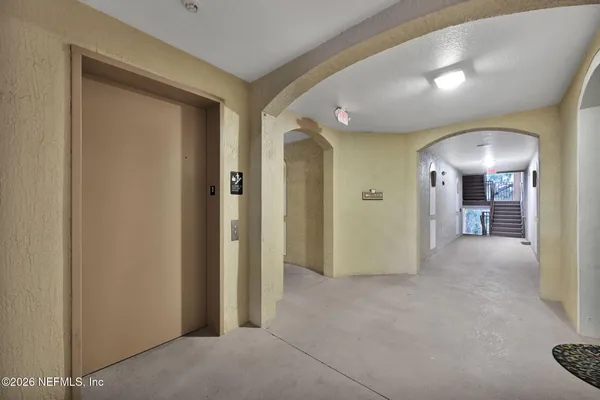a view of a hallway with wooden shelves