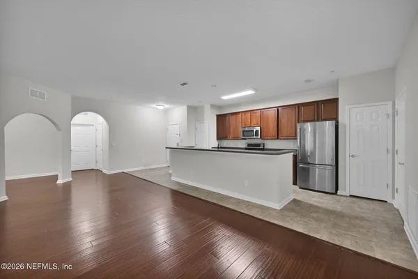 a view of kitchen with stainless steel appliances granite countertop a refrigerator a sink and a stove