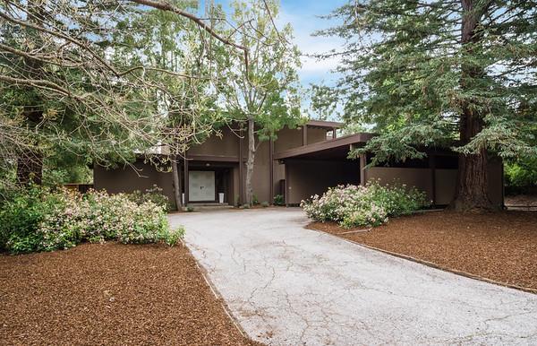 front view of a house with a yard and an trees