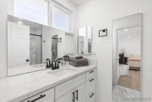 a bathroom with a sink and a mirror with bathtub