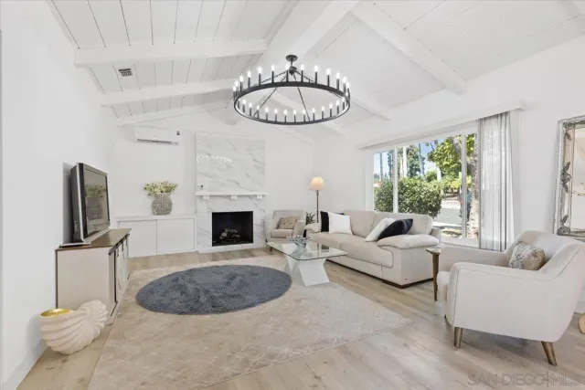 a living room with furniture a fireplace and a large window